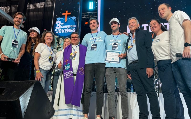 El equipo de Proyecto Santo Hermano Pedro junto a un sacerdote y organizadores en el escenario del 3.er Congreso de Jóvenes Fíltrate
